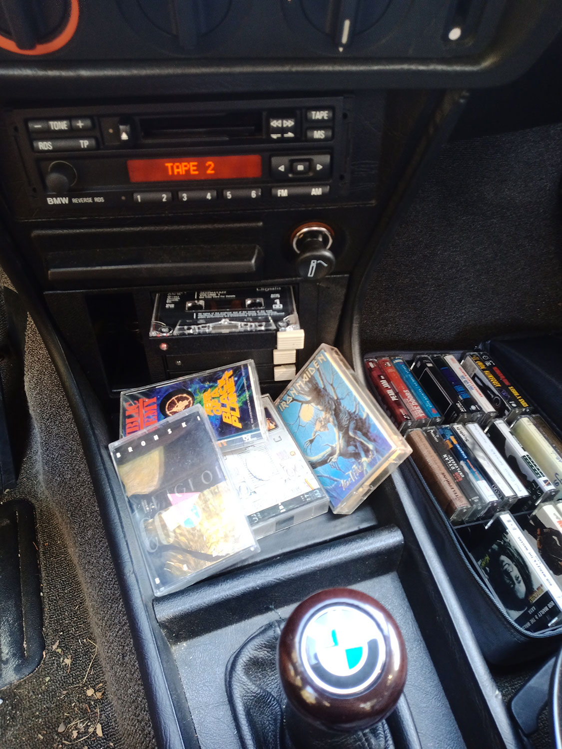 Detalle del radiocasete BMW y cintas de época en el interior del E21 — detalle de fotografía de producto