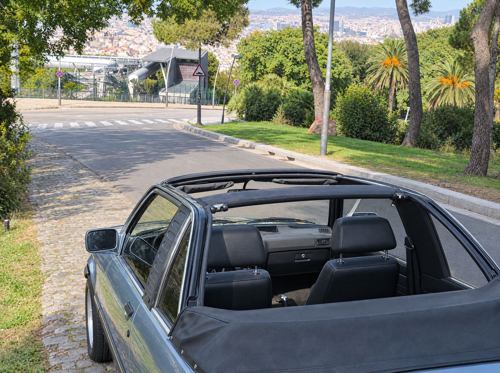 Looking into the open cabin of the BMW E21 Baur past the roll-bar, Montjuïc road behind